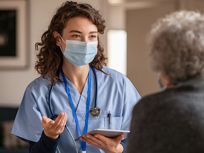 Female nurse practitioner talking to an older female patient